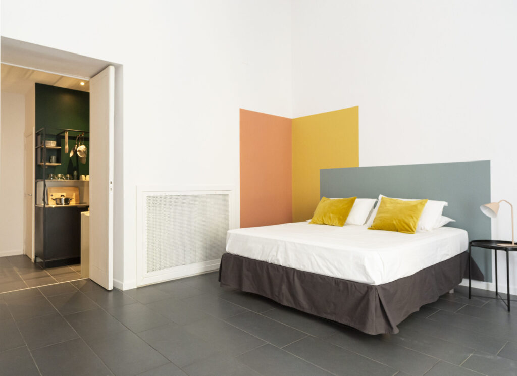 Hero image Lumina Apartment Napoli holiday home bedroom and kitchenette